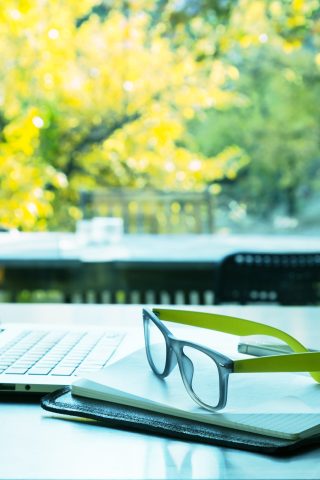 computer and glasses in office surrounded by outdoors - sustainability in 2023