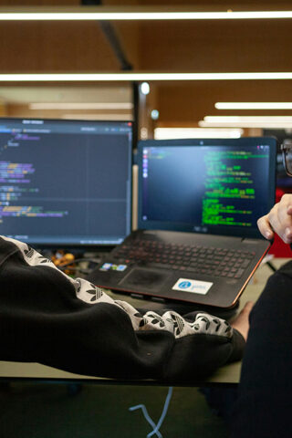 two men in front of computer showing code - IT sustainability in businesses