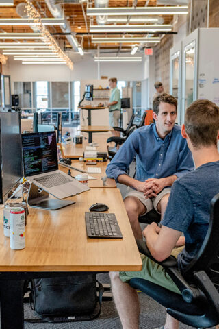 Group of men around desk - IT Sustainability